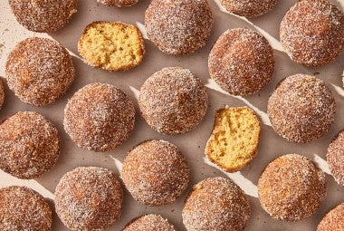 Apple Cider Doughnut Holes laid out on parchment paper