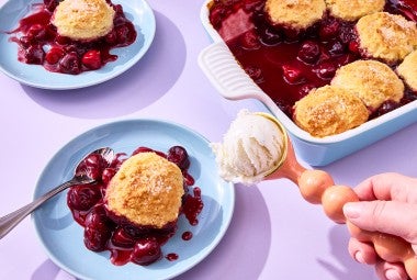 Buttermilk Biscuit Cherry Cobbler on a plate with ice cream being scooped