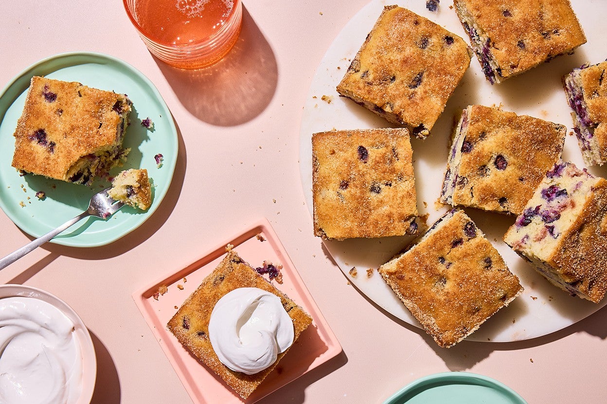 Easy Blueberry Muffin Cake served on a plate with whipped cream