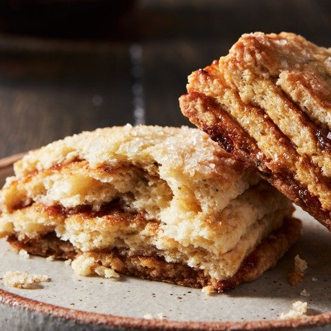 A Layered Fig Scone on a plate, broken in half, to reveal stripes of fig jam.