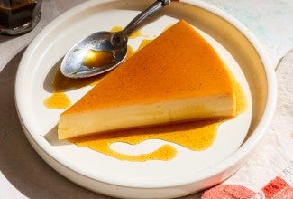 A slice of flan on a white plate.