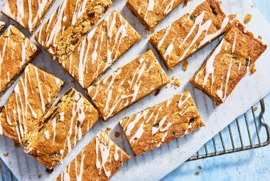 Oatmeal Raisin Cookie Bars sliced up on parchment on a cooling rack