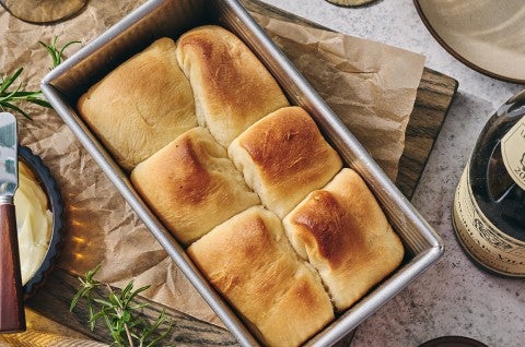 A loaf pan filled with freshly baked Small-Batch Parker House Rolls. - select to zoom